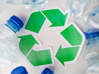 Logo vert de recyclage entouré de bouteilles plastiques vides