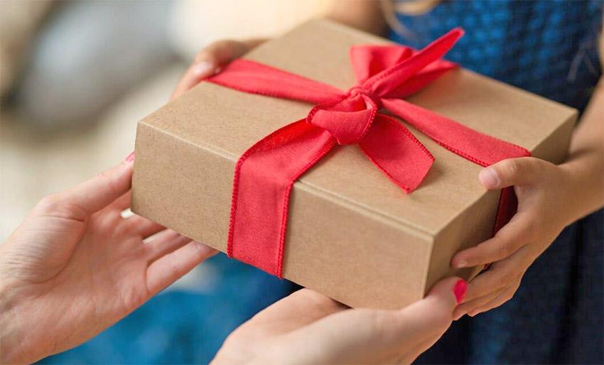 Remise d'un cadeau emballé dans une boîte marron avec un nœud rouge