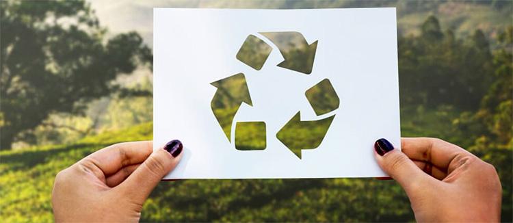 Vrouw houdt bord vast met symbool van recycling