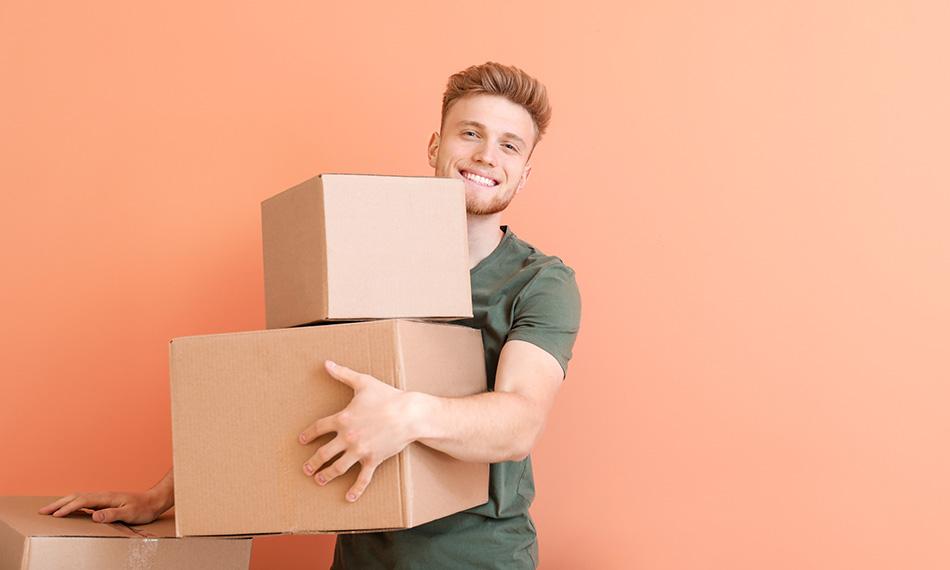 Un homme tient des cartons empilés