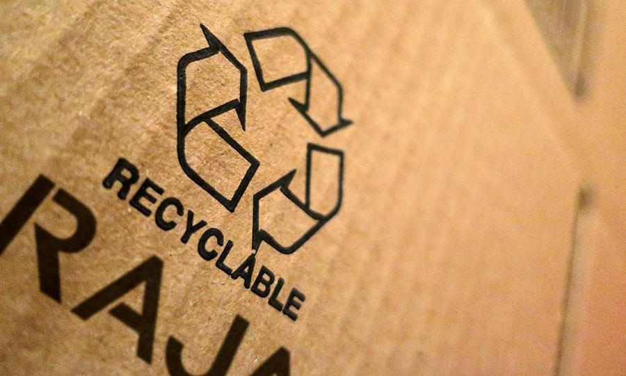 Gros plan sur un packaging écologique avec le logo du recyclage et RAJA