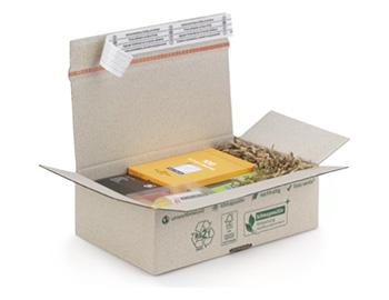 Caisse en papier d'herbe comme exemple de packagings écologiques, remplie de frisures et de petites boîtes.