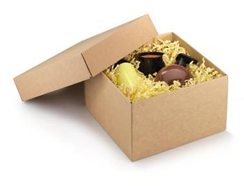 Boîte cadeau en carton avec couvercle amovible, rembourrée avec des frisures de papier et des produits cosmétiques.