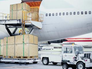 Houten transportkisten worden ingeladen in een vliegtuig