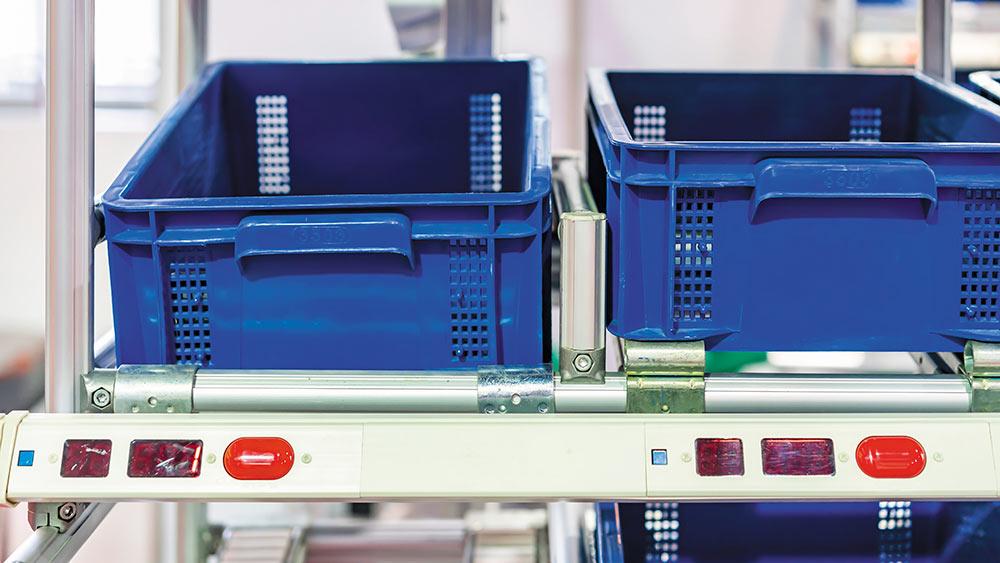 Bacs d'entrepôt bleus prêts à être remplis grâce à la technologie "pick to light".