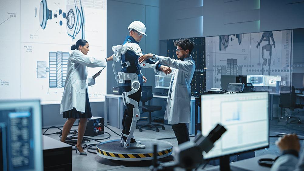 Des technici testent un exosquelette humain sur un employé d'entrepôt