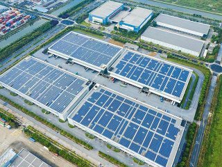 Magazijnen in een industrieterrein met een daken vol zonnepanelen voor een groenere logistiek